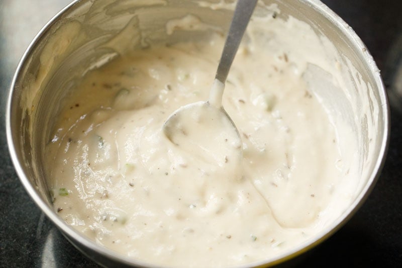 whisking mysore bonda batter with spoon