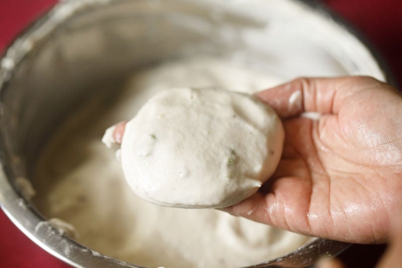 taken a round portion of vada batter on the fingers