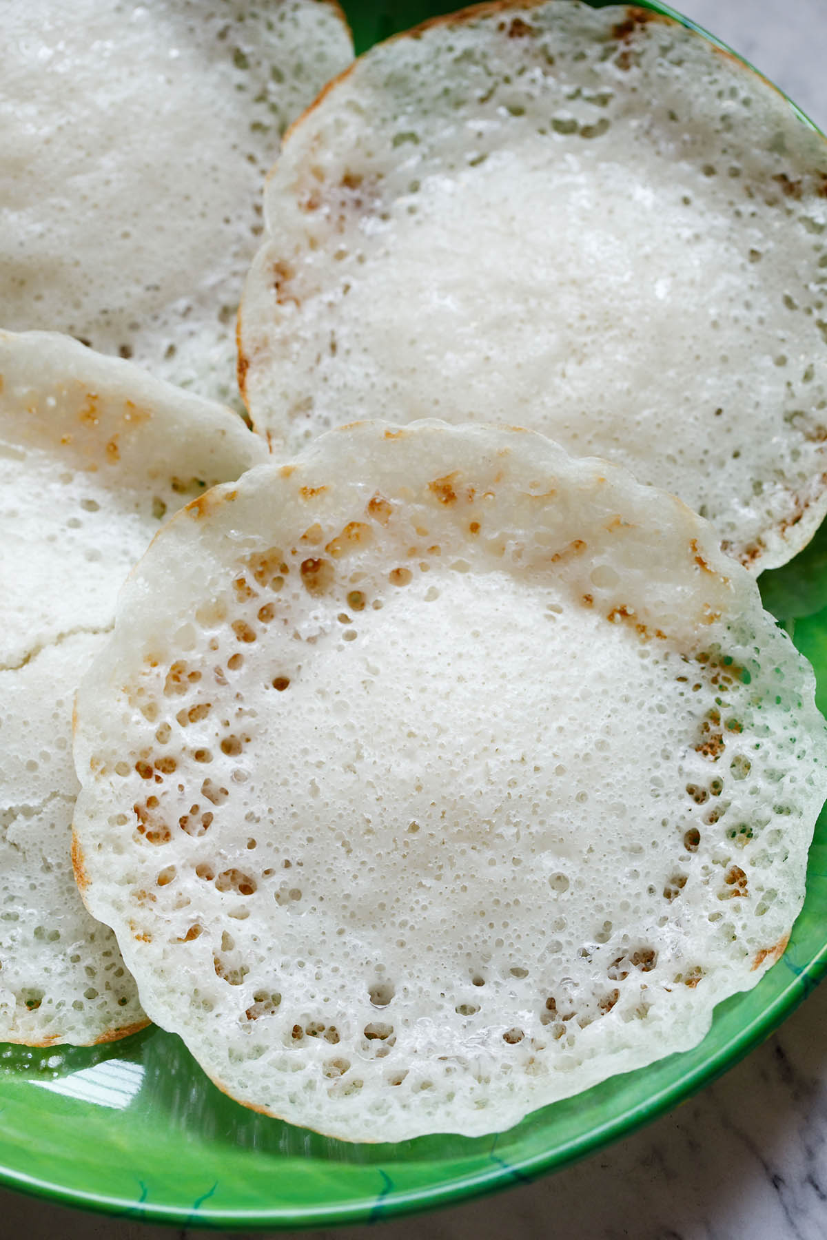 closeup shot of appam on green plate