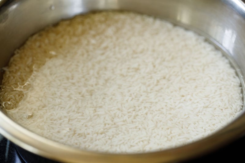 rice soaking in water in a steel bowl