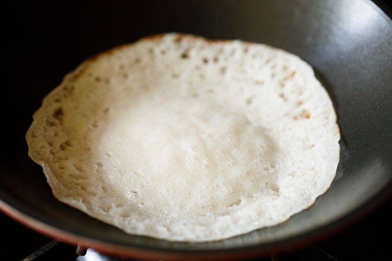 completed cooked appam is lightly golden around the edges of the pan