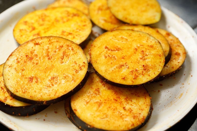 spices coated evenly on baingan or eggplant rounds