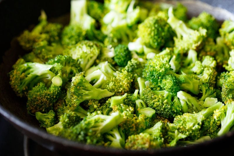 adding broccoli florets to the pan