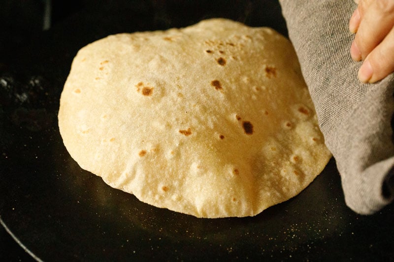puffed chapati or phulka roti with napkin being pressed at the side