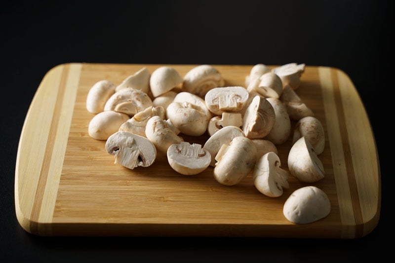 chopping mushrooms on a bamboo chopping board