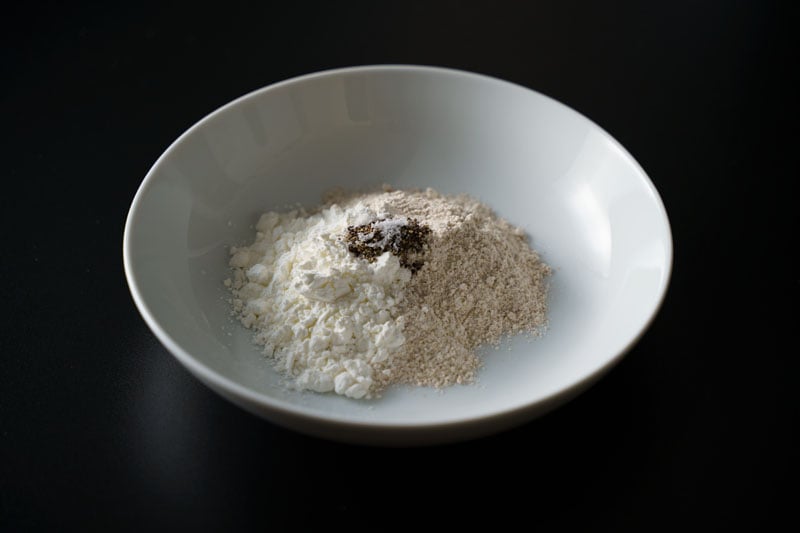seasonings added to flours in a white bowl