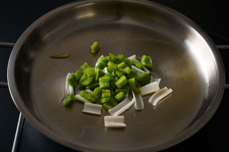 capsicum and spring onion whites on skillet