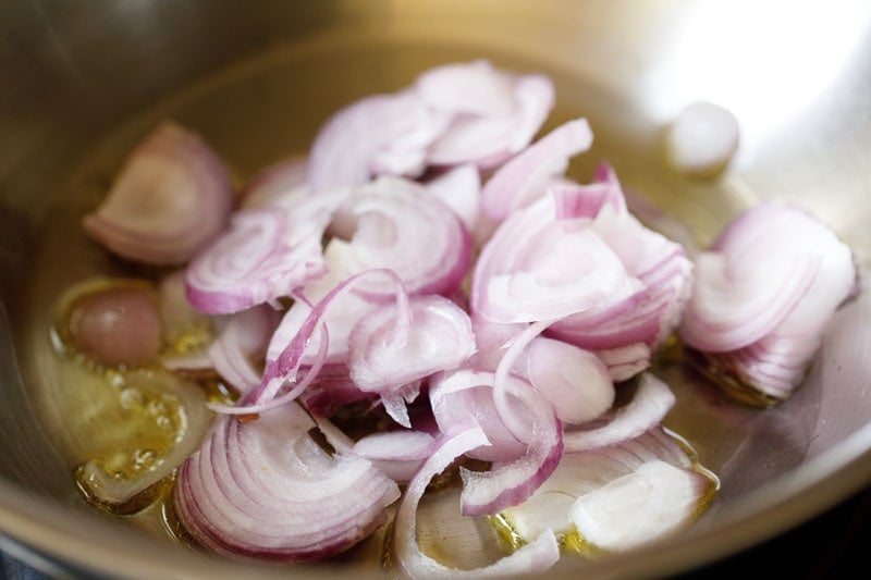 sliced onions in a sauté pan with oil