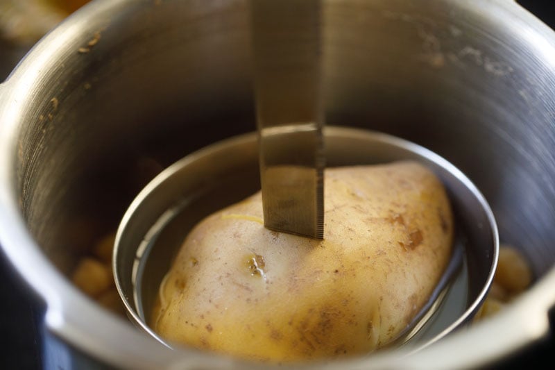 checking cooked potato with a knife