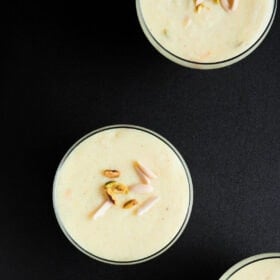 overhead shot of phirni in glass bowls on black board