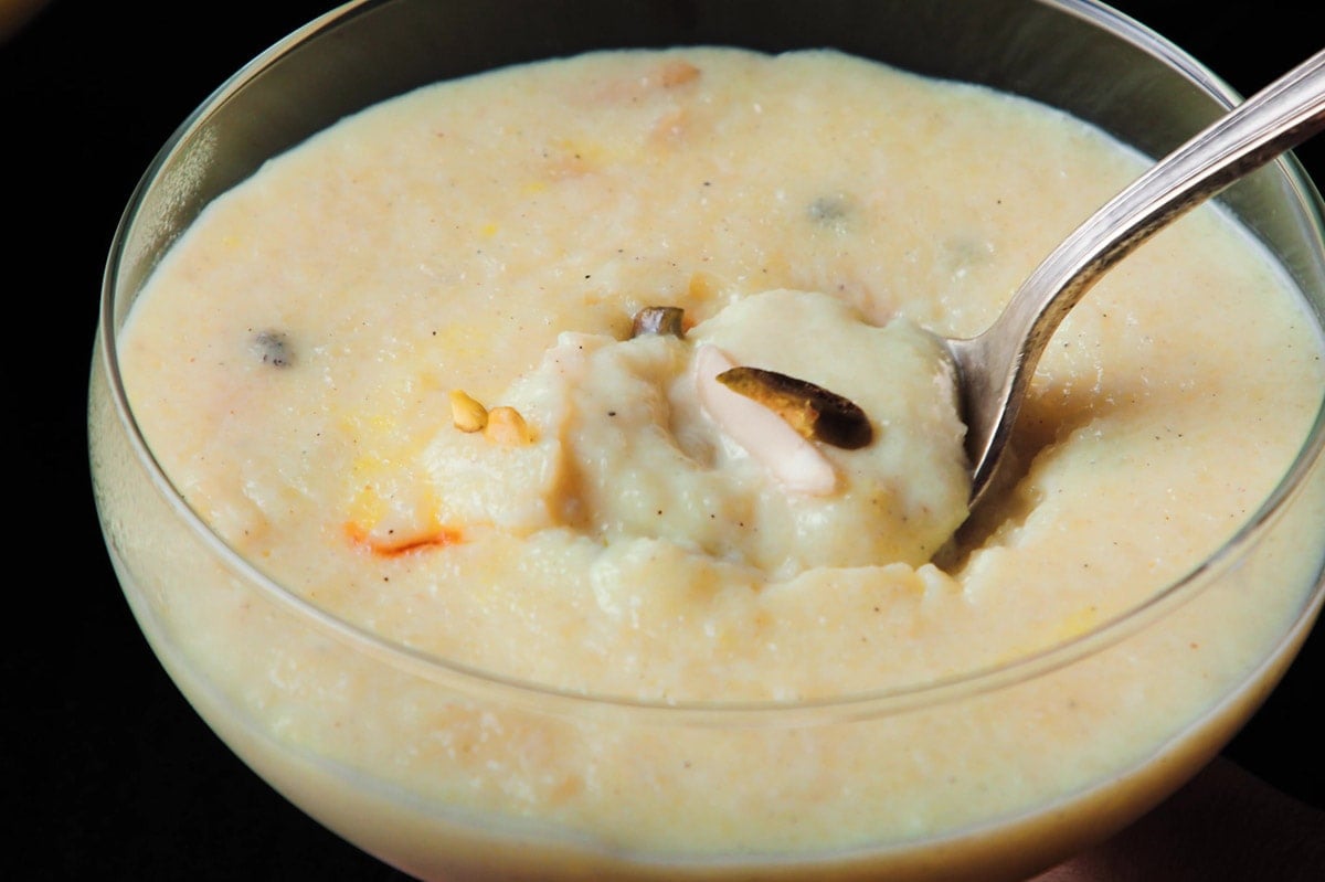 phirni in glass bowl being removed with a silver spoon