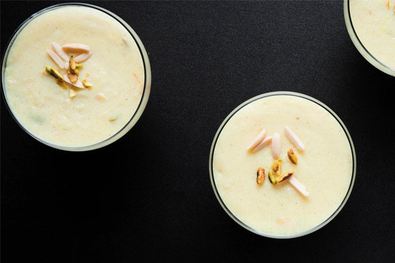 overhead shot of phirni in glass bowls on black board