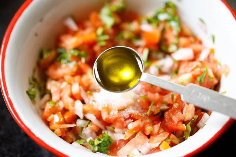 teaspoon of olive oil being added