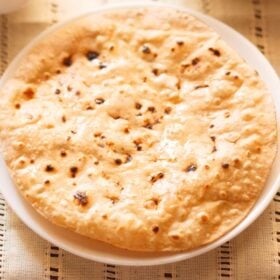 roti or chapati in a white plate on a cream cotton fabric