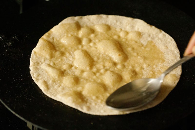 oil being spread on chapati