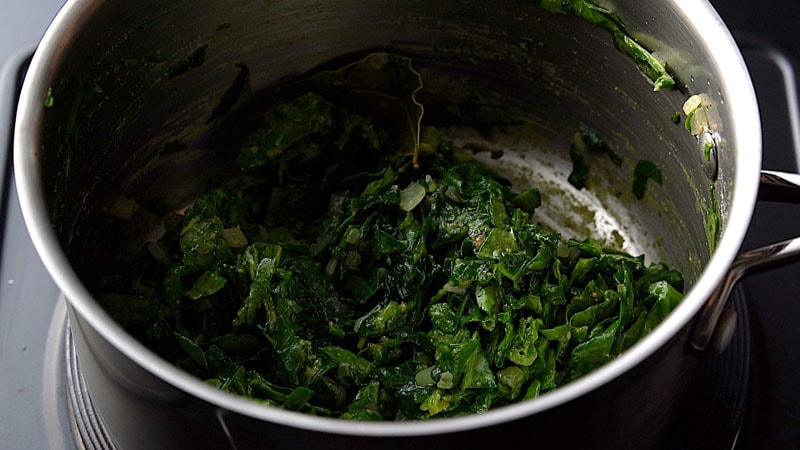 spinach and other ingredients mixed in pan