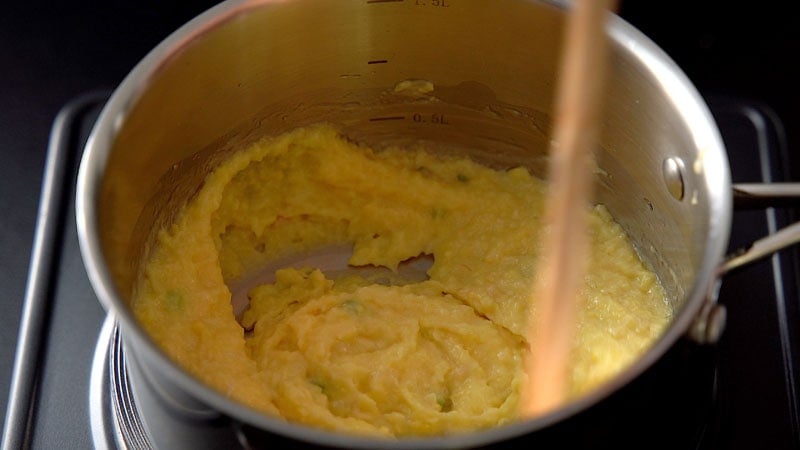 corn paste being mixed with wooden spoon