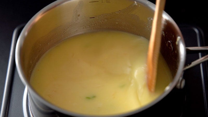water being mixed with wooden spoon with the corn paste