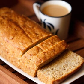 banana bread loaf with a few slices on a white tray