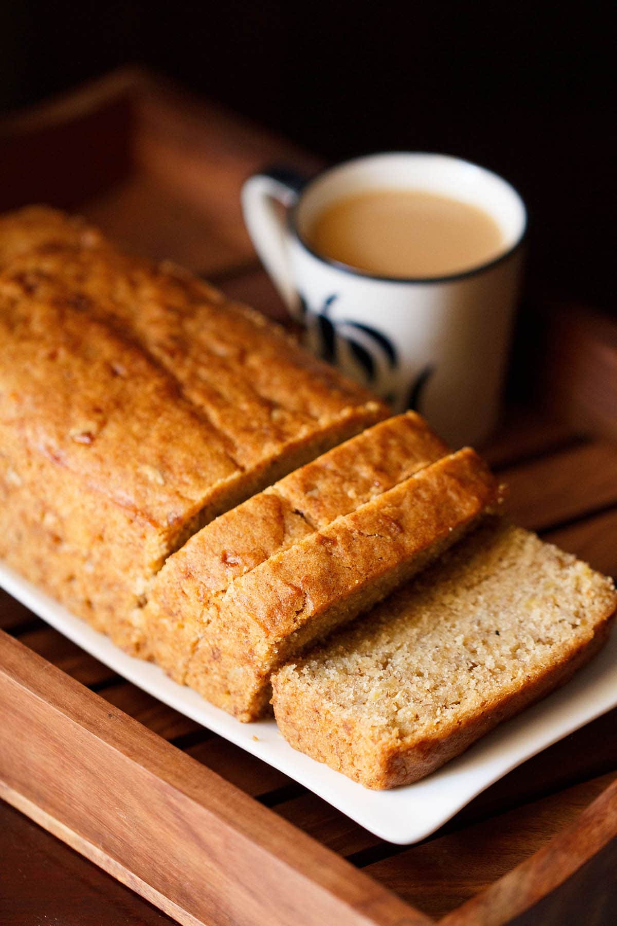 banana bread loaf with a few slices on a white tray