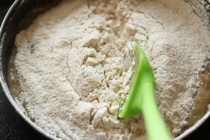 green spatula inside the flour for the mixture to be folded