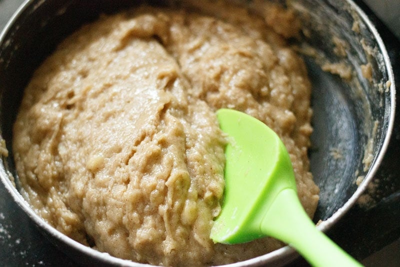 Batter in black pot with green spatula