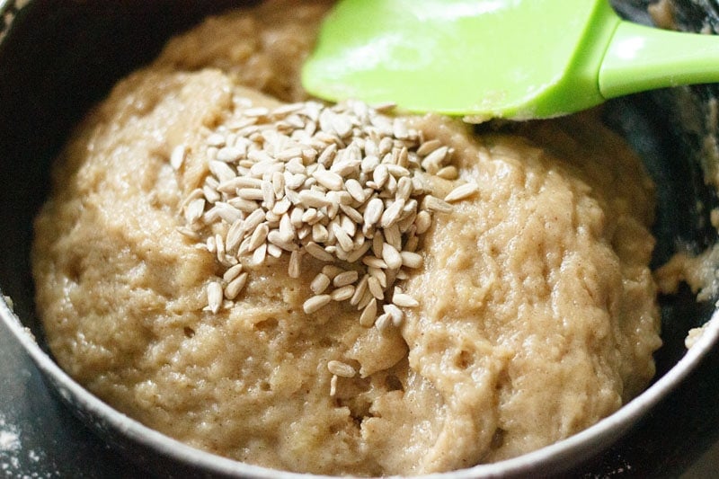 Batter with pile of sunflower seeds on top in black bowl