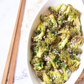 overhead shot of broccoli stir fry served on a white oval plate with wooden chopsticks by the side with text layovers.