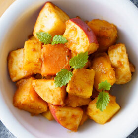 closeup shot of fruit chaat garnished with mint sprigs in white bowls