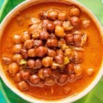 overhead shot of kadala curry in a green bowl on a green plate.