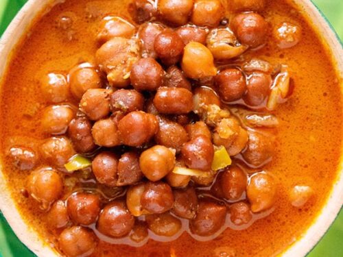 overhead shot of kadala curry in a green bowl on a green plate.