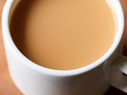 masala chai in white cup on brown board