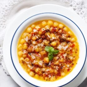 overhead shot of ragda with a ming sprig in center filled in a blue rimmed white bowl