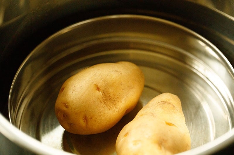 two potatoes in a steamer pan