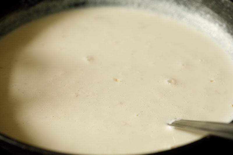 stirring sheer khorma while noodles cook