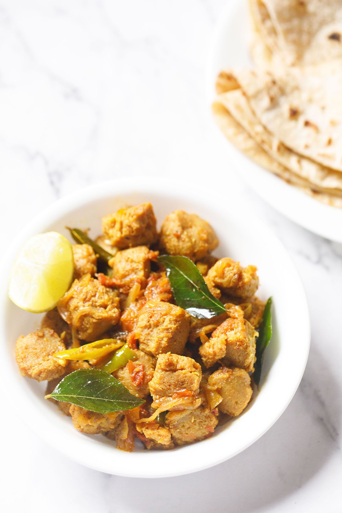 soya chunks fry in a white bowl with a lemon wedge