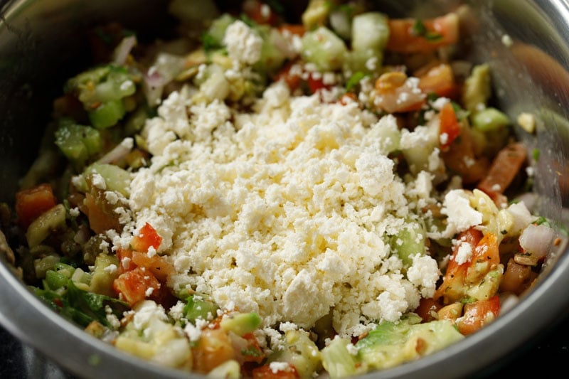 crumbled feta added to bowl