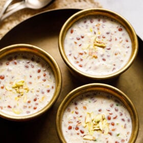 three brass bowls filled with basundi on a brass plate