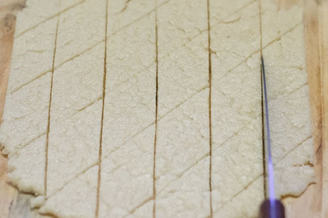 cutting rolled dough with a knife to make diamond shaped pieces