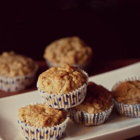 banana muffin placed on top of two banana muffins in a white tray