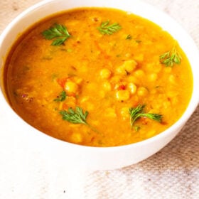 chana dal garnished with coriander (cilantro) leaves in a white bowl