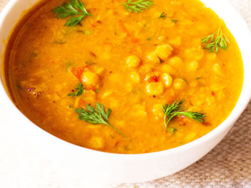 chana dal garnished with coriander (cilantro) leaves in a white bowl