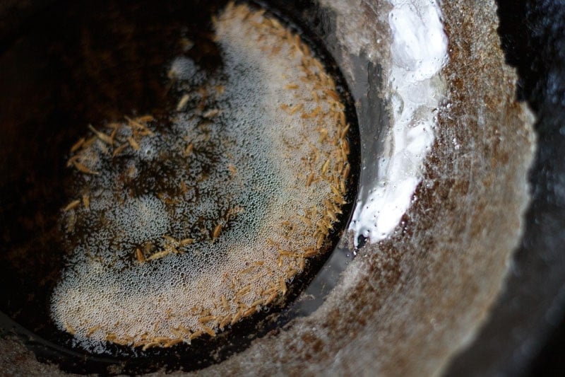 cumin seeds crackling in oil in a wok