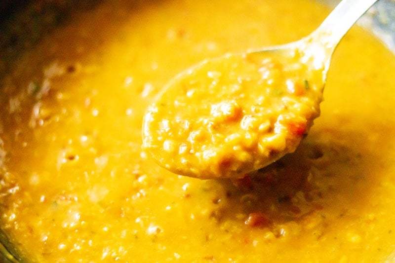 consistency of chana dal shown with a steel serving spoon