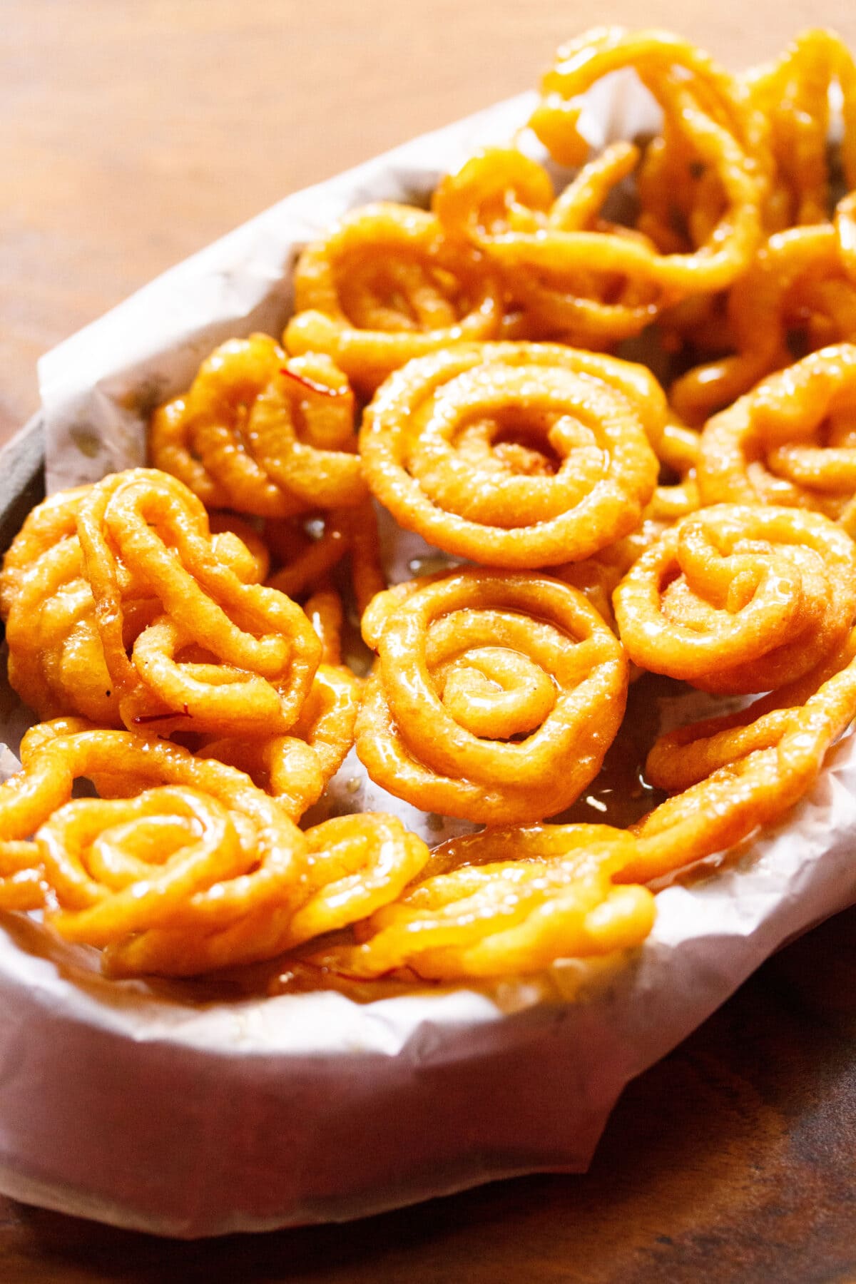 jalebi in a basket lined with parchment paper