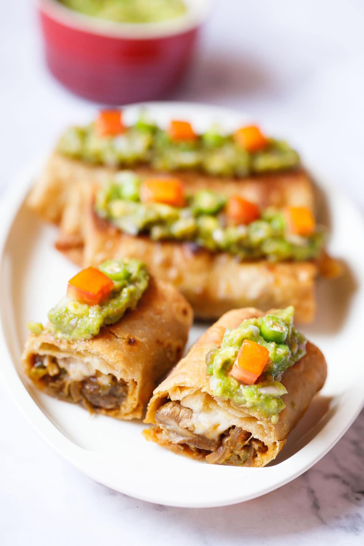 sliced chimichanga halves showing the fillings on an oval plate