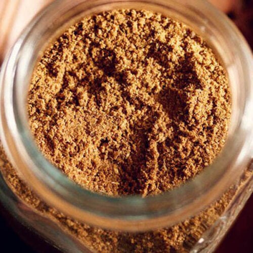 overhead shot of garam masala powder inside a glass jar