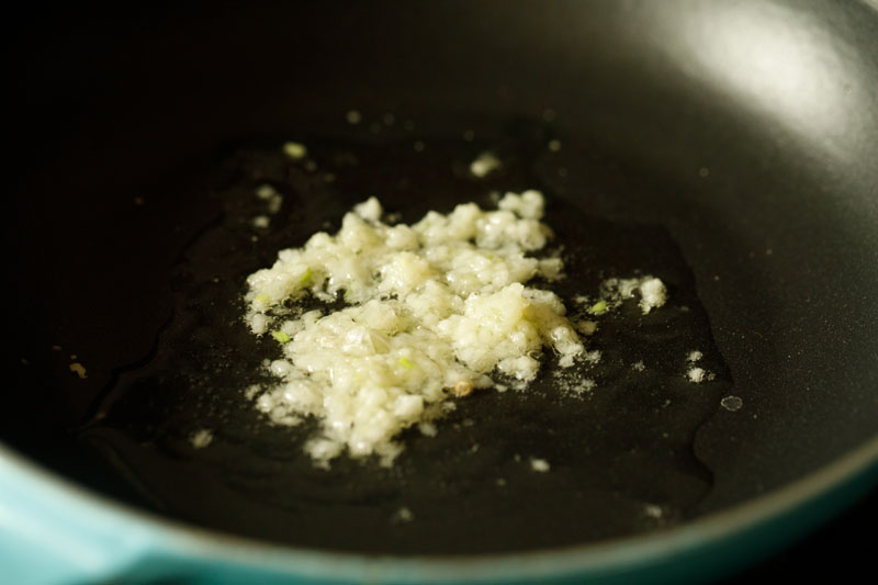 garlic frying in oil in a nonstick pan.