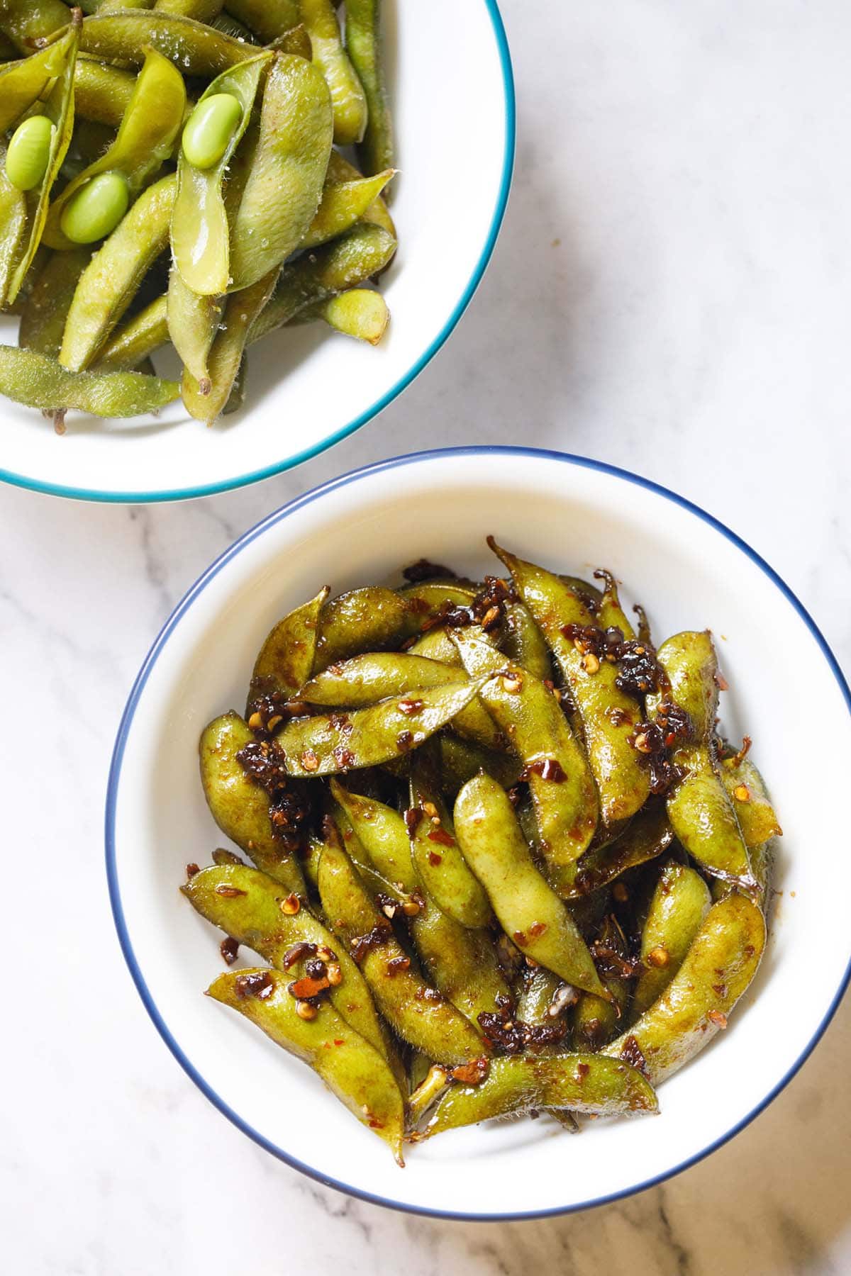 spicy edamame or soyabean chilli garlic in blue rimmed white bowl.