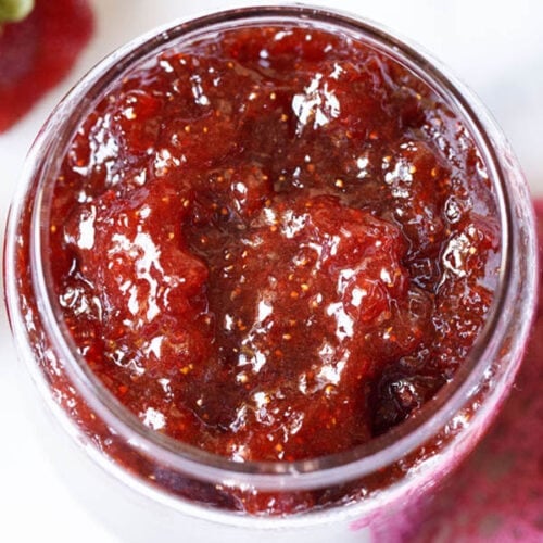 overhead shot of easy homemade strawberry jam in a clear glass jar